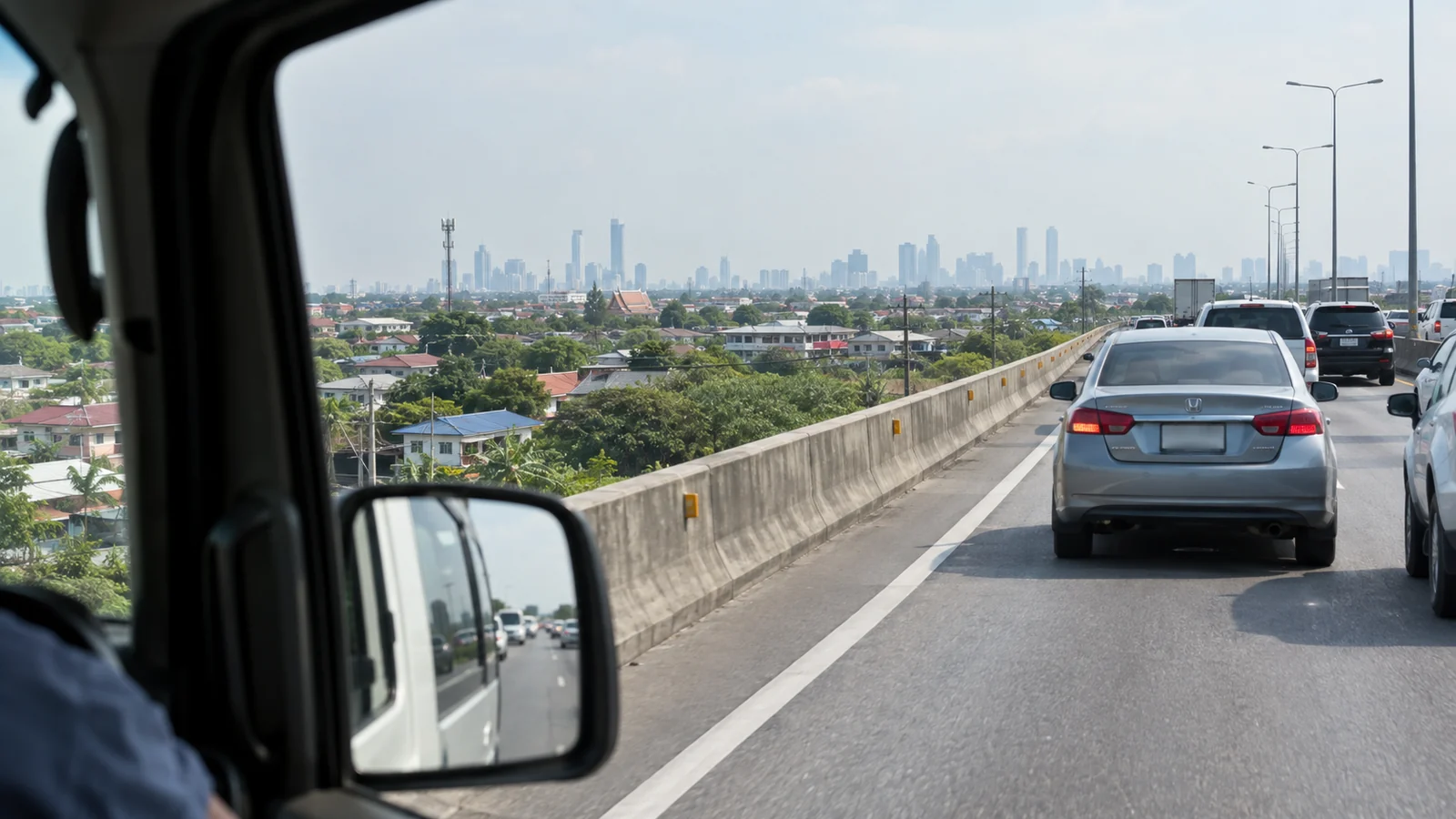 Slow traffic on an elevated expressway with the Bangkok skyline in haze