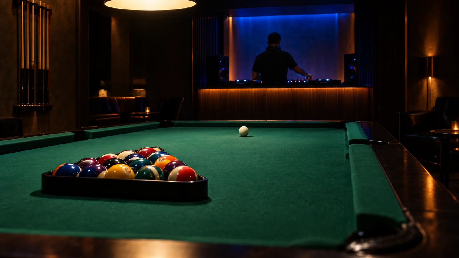 A full-size pool table in the foreground of a large private party room in an upscale Bangkok club, with a compact DJ booth glowing at the back wall