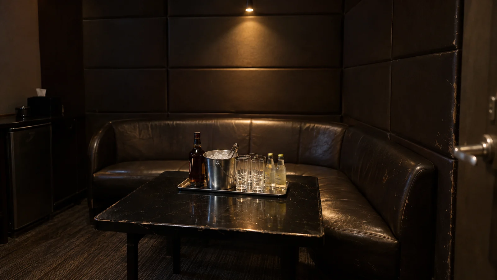 A small VIP room set for four, bottle on the table, no one in it yet
