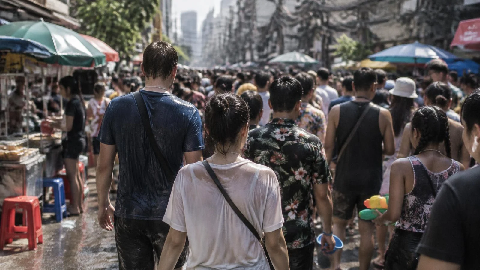 A dense daytime crowd filling a Bangkok street during a festival weekend