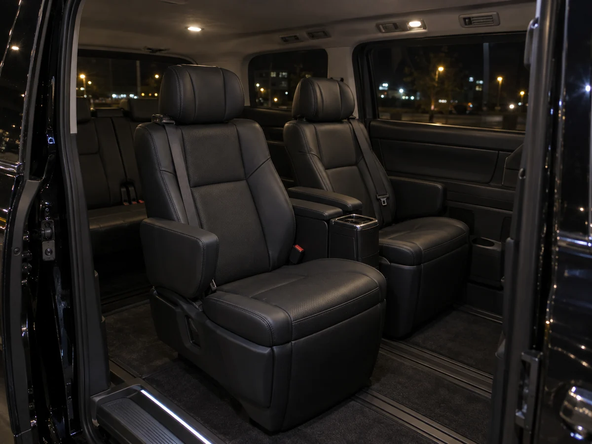 A luxury van waiting outside a hotel at night