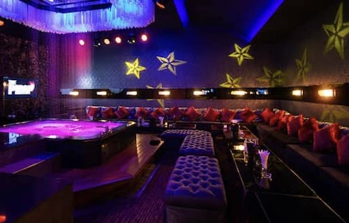 A large private party room with sofas around a pool table