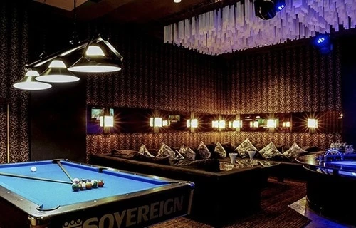 A private party room lit in red with seating along both walls