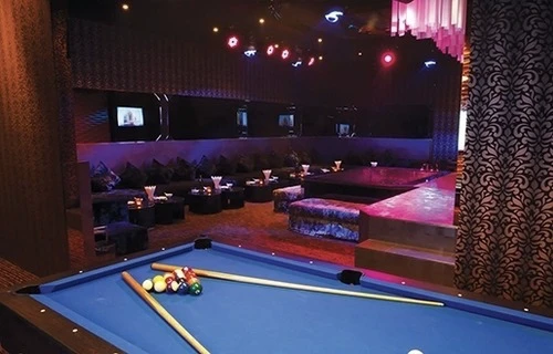 A private party room with a long sofa, a table and a dance space