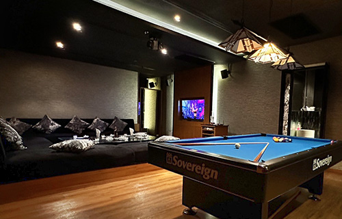 A private room with a pool table and a wide corner sofa