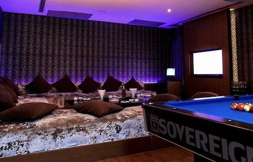 A large private room with a pool table and low seating