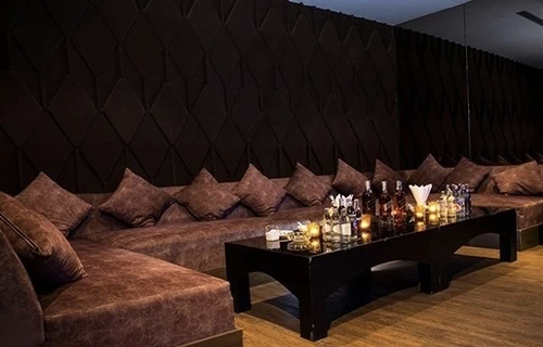 A medium private room with a curved sofa and a screen